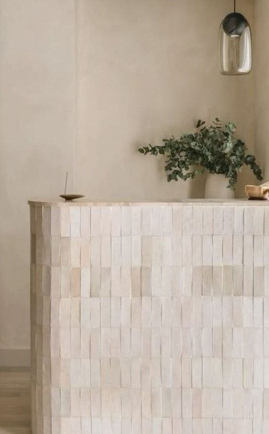 A carved wooden reception desk beneath soft light