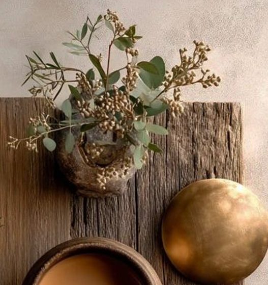 Dried eucalyptus in a stone vessel on weathered oak