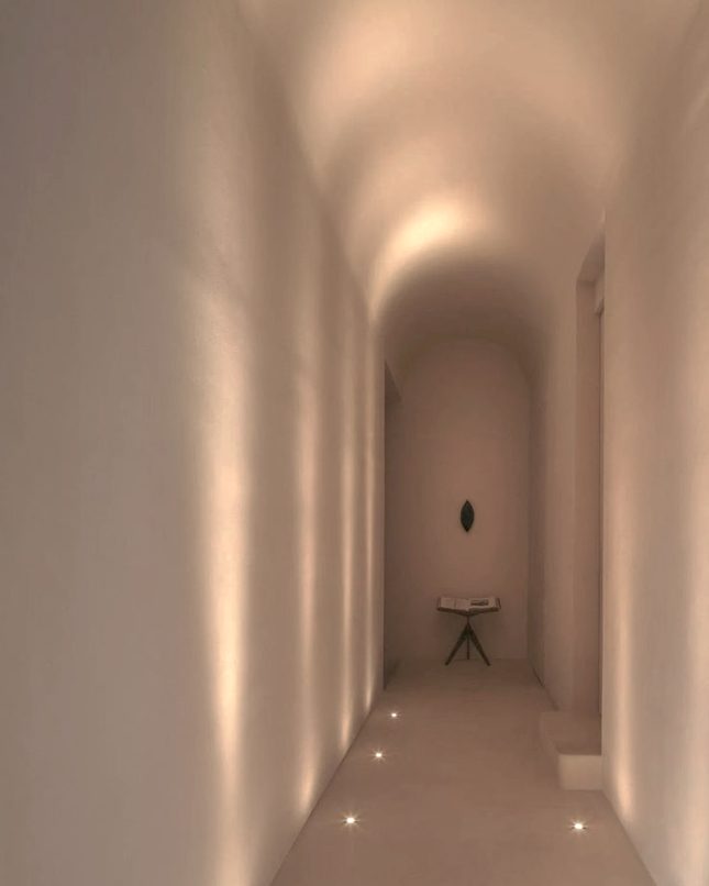 A softly lit vaulted corridor with floor lights